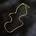 Élégant collier à chaîne torsadée dorée présenté sur un fond de soie noire de luxe - Collier / Doré