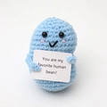 Close-up of blue crochet bean doll holding a card saying You are my favorite human bean - Pea Light Blue