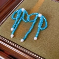 Detail of bow-shaped stud earring with blue faceted beads and white faux pearls - S925 Silver Needle Style / Blue