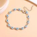 Macro view of Turkish Evil Eye bracelet with blue beads and adjustable lobster clasp - White Gold Tone