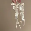 Dettaglio di orecchini eleganti con fiocco e perle con nastri in seta e perline - Orecchini a clip / Bianco