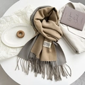 Macro detail of camel and grey dual-tone cashmere-style scarf with woven label and fringe - Camel Gray