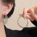 Detailed close-up of double-layered silver hoop earrings with a polished mirror finish - 5cm / Double Layer Polished Hoop / Silver