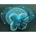 Top view of a teal bridal fascinator with mesh veil and feathers on green marble surface - Lake Blue