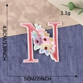 Pink letter N embroidered patch with colorful floral accents and green leaf details - Letter N / Hot Melt Adhesive