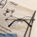 Detail of half-frame black metal glasses resting on vintage French style canvas background - Silver Frame Clear Lenses