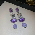 Vue macro de boucles d'oreilles vintage en argent avec relief chat et pierres mauves - Violet (Tige d'oreille en argent)