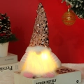 Close-up view of a glowing Christmas gnome featuring a rose gold sequin hat and fur beard - Pink