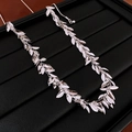 Detailed macro view of silver leaf-shaped metallic necklace on black display tray - Silver