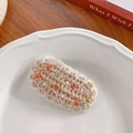 Handmade knitted beige oval flower hair clip with orange and yellow pom-pom accents - 8-Coffee Dotted