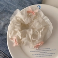White lace scrunchie with pink silk bows on a decorative ceramic plate with denim - Fair Skin White