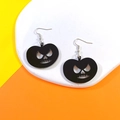 Dettaglio di orecchini a zucca neri su vassoio bianco per la moda di Halloween - Zucca