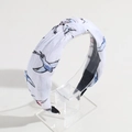 Detail of white knotted headband with blue and pink bird print on transparent stand - White Bird Print