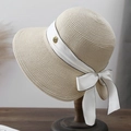 Dettaglio cappello di paglia beige con nastro di seta bianca e distintivo rosa dorata - Beige