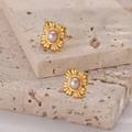 Goldene Blumen-Ohrstecker mit weißer Perle auf minimalistischem Travertin-Display - Kreuz