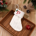 White knitted Christmas stocking featuring red embroidered letter P and green holly leaves - Letter P