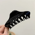 Detail view of large 12cm black high-gloss shark hair clip with strong grip design - Glossy Black