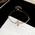 Detail van verstelbare gouden armband met roze kristallen kruis en micro-zirkonastenen - Goud-Kruis