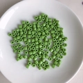 Macro view of light green cylindrical acrylic beads on a white ceramic plate - 8# Light Green