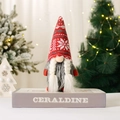 Christmas gnome plush toy with red snowflake knit hat and white braids on grey book stand - C4-1 Women's Snowflake Hat
