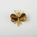 Golden butterfly brooch featuring heart-shaped brown tiger eye stone wings on white background - Tiger's Eye