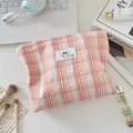 Detail of checkered makeup bag with textured fabric and colorful SOZ AKKA label - Pink