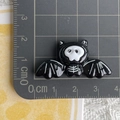 Macro shot showing 4cm black skull bat resin charm on a metric scale cutting mat - 8* Black Skull Bat