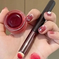 Rode lippencrème textuur testen op de hand met een siliconen penseel voor precisie - Ronde Lippenstiftkwast