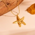 Dettaglio di un ciondolo a stella marina dorata su catena a serpente su sfondo di legno - Collana stella marina oro
