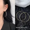 Detailed view of 6cm large gold hoop earring with model side view for size perspective - 6cm / Minimalist Hoop / Gold