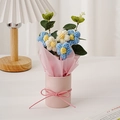Handgemachter Häkelblumenstrauß mit fünf blau-weißen Puffblumen in einem rosa Eimer - Blaue Puffblume (Runder Eimer + Fenstertasche + Licht)