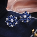 Detail of luxury sunflower zircon earrings in sapphire blue on deep blue velvet box - Silver & Blue