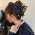 Détail d'une élégante pince à cheveux en tweed bleu marine avec bouton doré sur modèle - Pince à cheveux - Bleu / Bleu