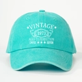 Close-up of VINTAGE 1973 white printed text on mint green washed cotton baseball cap - One Size / Lake Blue