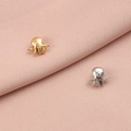 Marine octopus charms in gold and silver finish for DIY jewelry making on fabric background - Octopus