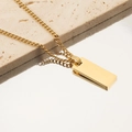 Close-up of a gold-plated rectangular pendant on a cuban chain over a reflective stone surface - 18K Gold Plated