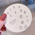 Detail shot of a 7-pair set including silver bow, pearl, and star studs on a card - Silver Simple Geometric (E0073-1)
