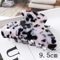Detail shot of a 9.5cm black and white marbled acetate hair claw clip with glossy finish - 9.5CM / Black and White Speckled