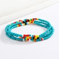Detail of colorful handmade glass seed bead body chain with vibrant bohemian contrast colors - Blue Red Yellow Black White