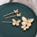 Elegante set di 4 fermagli per capelli a farfalla dorati su un piatto decorativo verde scuro - Set da 4 Pezzi-Oro