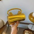 Golden acrylic cylinder evening bag with lion head handles and gold chain strap - Gold