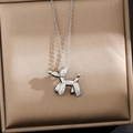 Detailed close-up of a silver balloon dog pendant with white zircons in a jewelry box - Silver Balloon Dog