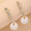 Macro shot of gold drop earrings with five sparkling rhinestones and a white pearl drop - Gold Pearl Rhinestone Drop (HE4019)