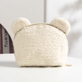 Dettaglio della borsa trucco orsetto in pile crema con texture morbida e zip in metallo - Bianco