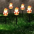 Set of 5 solar Christmas Santa Claus path lights glowing in the night lawn garden - Santa Claus