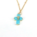 Macro shot of double-layered gold cross pendant with turquoise stones on slim chain - Turquoise Blue