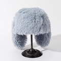 Detail view of light blue-grey plush earflap hat on a black vintage metal stand - M (56-58cm) / Gray