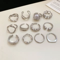 Flat lay of a 12-piece silver irregular geometric ring set with pearl detail - 12pcs Set / Silver
