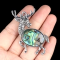 Vintage silver elk brooch with iridescent abalone shell inlay held by a hand - Abalone Shell