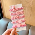 Close-up of 5-piece pink scrunchie set with bear, bow, and heart charms for girls - Pink Series 5-Piece Set